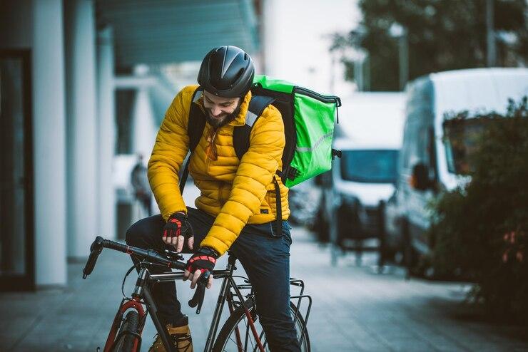 Un livreur qui range son sac sur son vélo